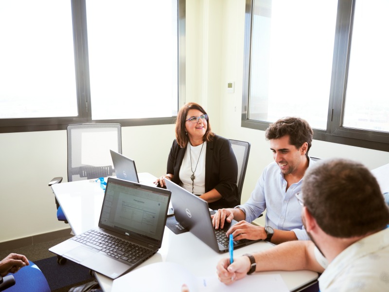 Employees with notebooks at a table in conversation