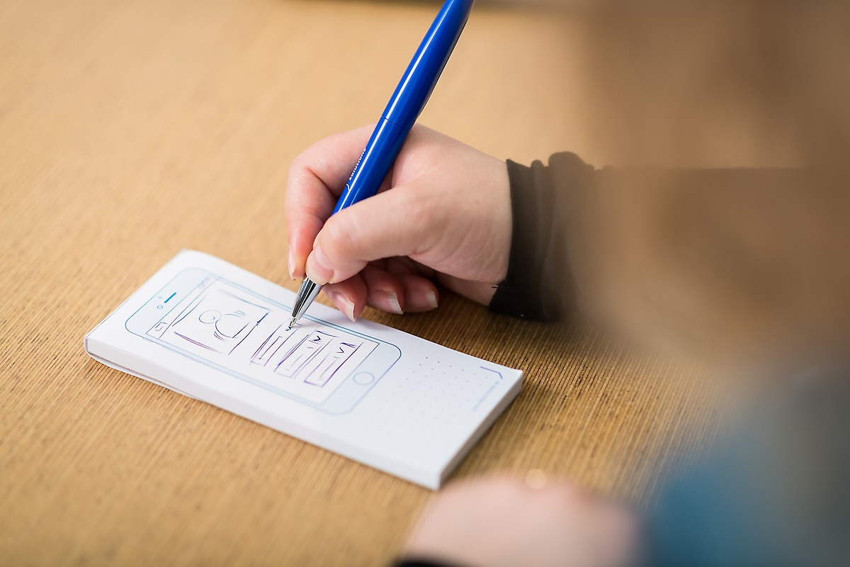 Someone draws a smartphone on a piece of paper Someone draws a smartphone on a piece of paper